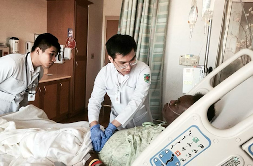 Medical students Mai Quang Minh and Le Bao Huy conducting a patient examination.